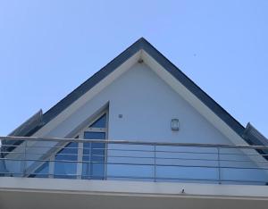 um edifício com uma varanda com um céu azul ao fundo em Blue bay studio terrasse em Deauville