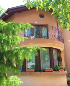 a balcony on a house with potted plants on it at Dimitrovi Guesthouse - Peaceful Stay near Beach with Garden, Sarafovo in Burgas