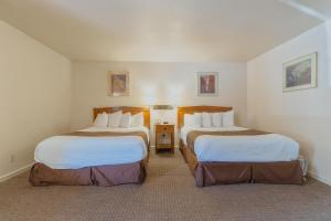 a hotel room with two beds in a room at Mariposa Lodge in Mariposa