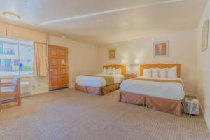 a hotel room with two beds and a window at Mariposa Lodge in Mariposa