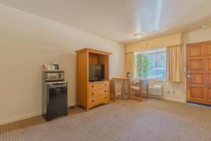 a room with a table and a television and a door at Mariposa Lodge in Mariposa