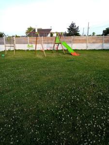 a green yard with a swing set in the grass at À La Maison Du Bonheur in Audruicq