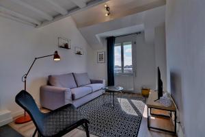 a living room with a couch and a tv at Appartement "MEZZA" centre ville de VITRÉ in Vitré