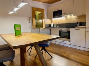 kuchnia z drewnianym stołem i krzesłami w obiekcie Appartementhaus Reiter w mieście Altenmarkt im Pongau