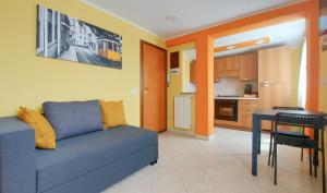 ein Wohnzimmer mit einem blauen Sofa und einer Küche in der Unterkunft CORSO MARCONI HOUSE in Civitavecchia