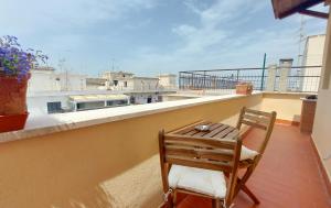 a wooden chair sitting on a balcony with a table at CORSO MARCONI HOUSE in Civitavecchia