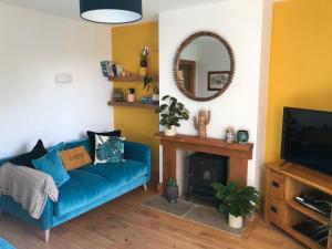 a living room with a blue couch and a mirror at Lazy Daze Cottage in Horsham