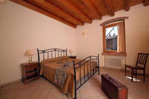 a bedroom with a bed and a chair and a window at Residence Borgo Mondragon in Lazise +55 photos