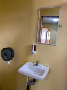 a bathroom with a sink and a mirror at Cabinas Popular in Puerto Viejo