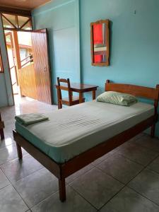 a bed in a room with a wooden floor at Cabinas Popular in Puerto Viejo