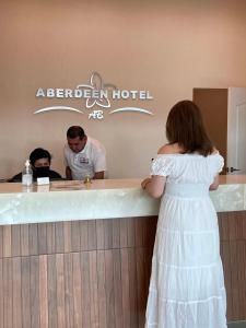 a woman in a white dress standing at a bar at ABERDEEN HOTEL DOLORES HIDALGO in Dolores Hidalgo