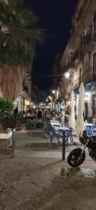 une moto garée dans une rue la nuit dans l'établissement Luxury Catania, à Catane