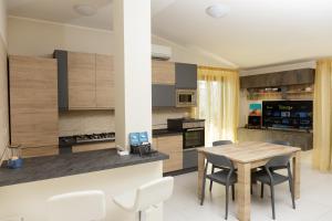 a kitchen with a wooden table and chairs at La Collina sul Mare Apartments in Petacciato