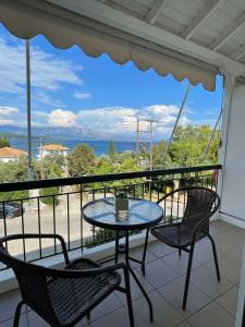 stół i krzesła na balkonie z widokiem na ocean w obiekcie Sunshine Apartments and Rooms w mieście Nikiana