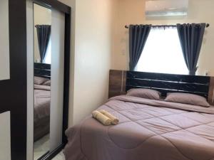 1 dormitorio con espejo grande y cama en Ranch Seda Mosegaard en Amphoe Khukhan