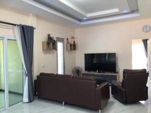 a living room with a couch and a flat screen tv at Ranch Seda Mosegaard in Amphoe Khukhan
