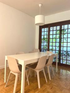 une salle à manger avec une table et des chaises blanches dans l'établissement Lisboa Central Apartment, à Lisbonne