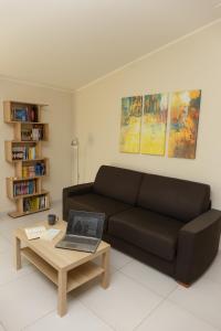 a living room with a couch and a coffee table with a laptop at La Collina sul Mare Apartments in Petacciato