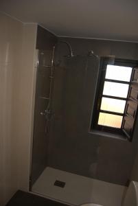 a bathroom with a glass shower with a window at Hotel Palacio de los Vallados in Lastres