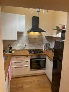 una cucina con armadi bianchi e un forno a piano cottura nero di Il Nido Del Borgo a Genova