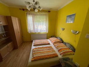een slaapkamer met 2 bedden in een gele kamer bij Csillám vendégház in Hajdúszoboszló