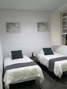 2 letti in una camera con pareti bianche di Acogedor apartamento con excelente ubicación. a Santa Cruz de Tenerife