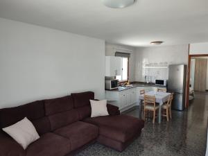 un salon avec un canapé marron et une cuisine dans l'établissement Casa Luisi, à Playa Honda
