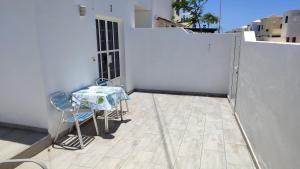 a patio with a table and chairs on a balcony at Casa Luisi in Playa Honda