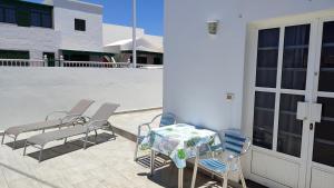 une terrasse avec une table et des chaises sur un balcon dans l'établissement Casa Luisi, à Playa Honda
