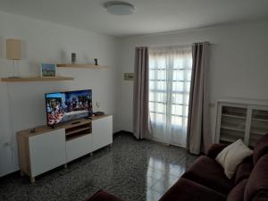 un salon avec une télévision et un canapé dans l'établissement Casa Luisi, à Playa Honda