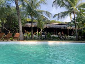 een resort met een zwembad en palmbomen bij LAGOA do VENTO ATINS in Atins