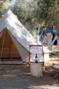 uma tenda branca com um espelho num toco em Camping Chania em Kato Daratso