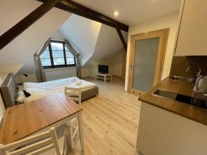 um quarto com uma cama e uma cozinha num sótão em Apartamenty w Rynku em Rabka