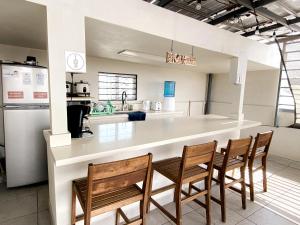 a kitchen with a counter with four chairs and a counter top at Paris Hostel in Tijuana