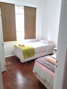 a bedroom with two beds and a window at Lindo quarto na Praia de Botafogo in Rio de Janeiro