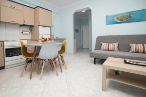 a kitchen and living room with a table and chairs at Blue Deluxe Apartment in Kallithea Halkidikis