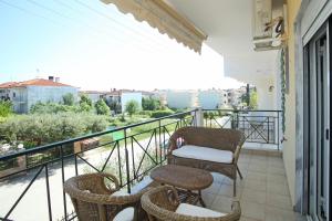 a balcony with chairs and tables on a balcony at Blue Deluxe Apartment in Kallithea Halkidikis