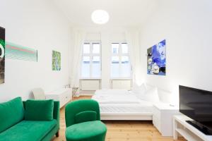 ein Wohnzimmer mit einem grünen Sofa und einem TV in der Unterkunft Apartment Berlin Zentrum in Berlin