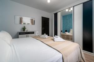 ein weißes Bett in einem Zimmer mit einem großen Fenster in der Unterkunft Dijamant Apartment in Split