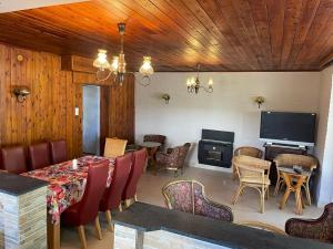 a dining room with a table and chairs and a television at Kovács Apartman Kunfehértó in Kunfehértó