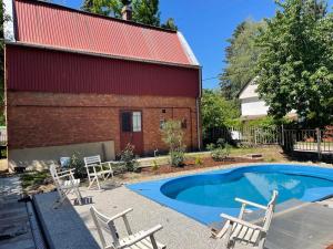 a swimming pool with chairs and a building at Kovács Apartman Kunfehértó in Kunfehértó