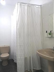 bagno con tenda da doccia bianca e servizi igienici di Acogedor apartamento con excelente ubicación. a Santa Cruz de Tenerife