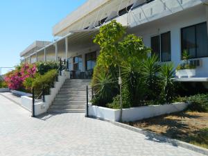 a building with stairs and plants in front of it at Telhinis Hotel & Apartments in Faliraki