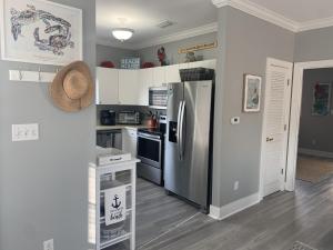 eine Küche mit einem Kühlschrank aus Edelstahl und weißen Schränken in der Unterkunft Beach4u 4bu By Pkrm in Pensacola