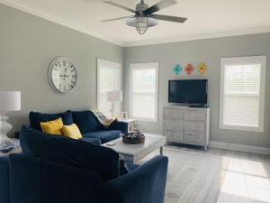 ein Wohnzimmer mit einem blauen Sofa und einem TV in der Unterkunft Beach4u 4bu By Pkrm in Pensacola