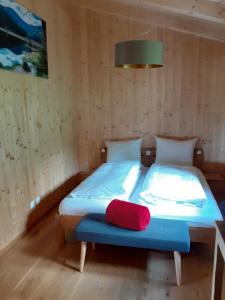 um quarto com uma cama com uma almofada vermelha em Chalet Muehlwiese em Lindberg