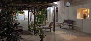eine Veranda mit einer Uhr an der Seite eines Gebäudes in der Unterkunft Lemon Tree Courtyard in Larnaka
