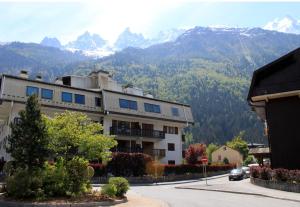 a building on a street with mountains in the background at Apartment Lyret in Chamonix