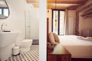 a bathroom with a bed and a bathroom with a toilet and a sink at Can Manseu in Sant Privat de Bas