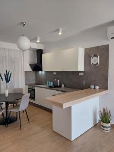 Una cocina con gabinetes blancos y una mesa de comedor. en Villa Moon Trogir, en Trogir